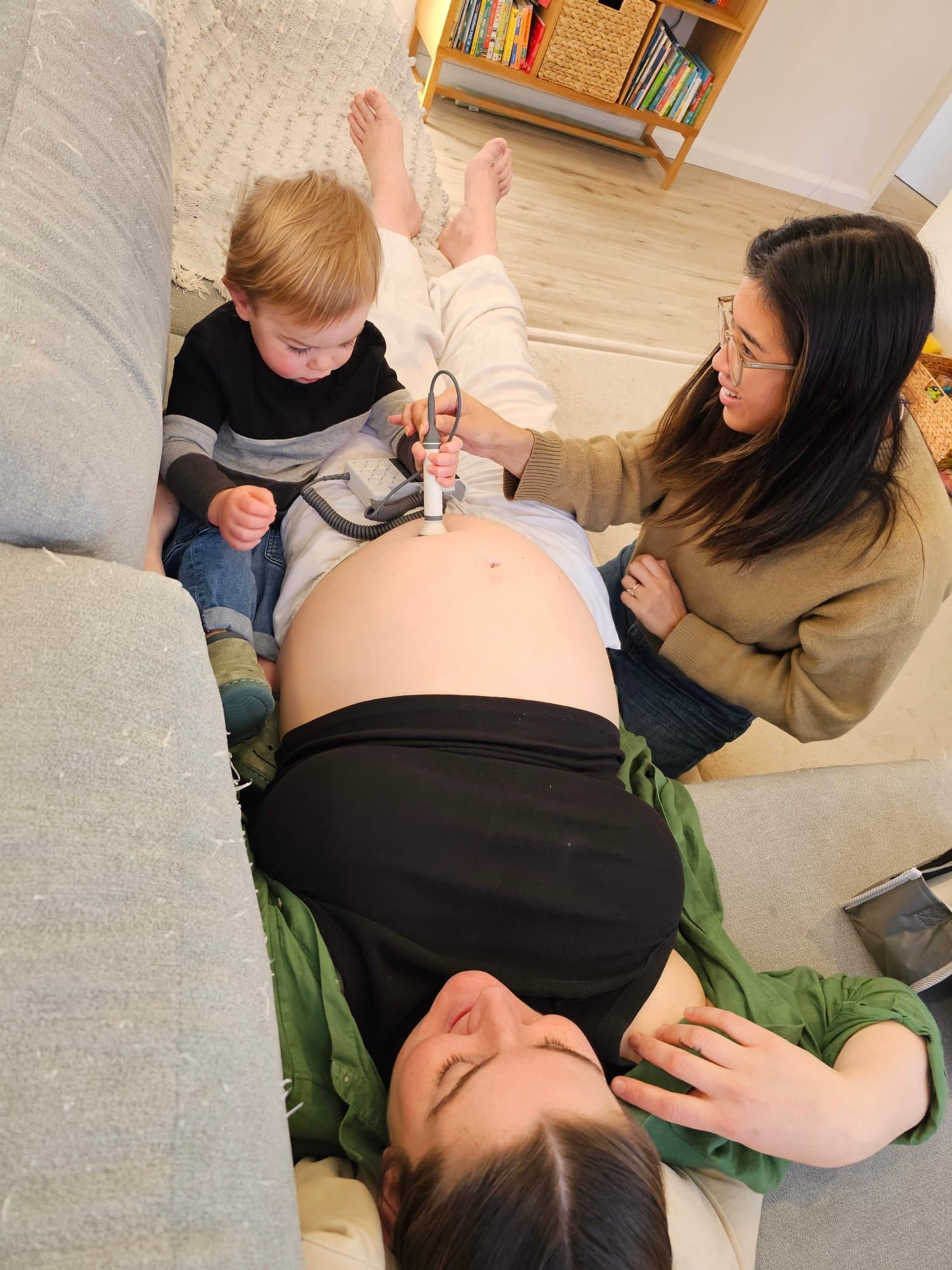 Angela helping sibling listen to baby during pregnancy home visit